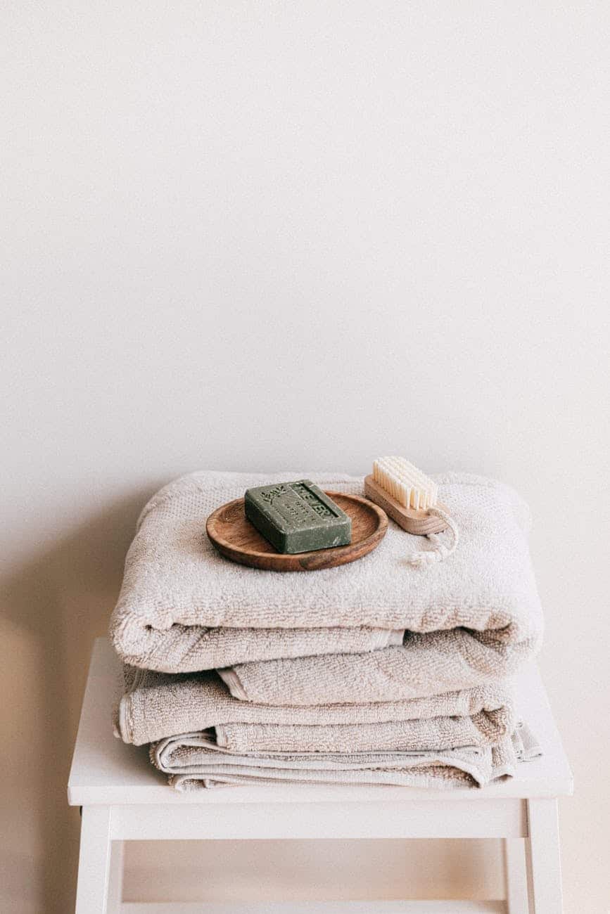 natural toiletries and towels on stool