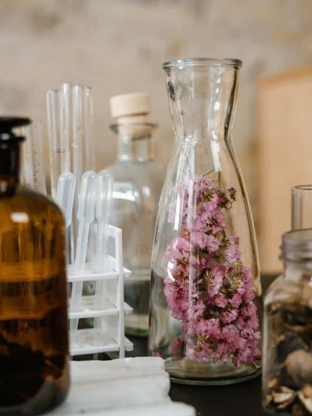 clear glass bottles on white wooden shelf